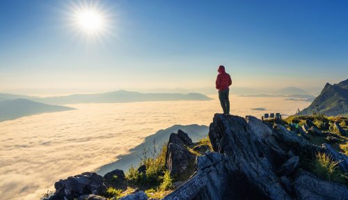 traveler-standing-rock-doi-pha-tang-morning-fog-chiang-rai-thailand